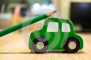 Closeup shot of green sharpened pencil on a green car toy