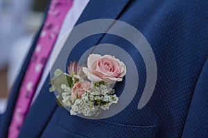 Closeup shot of the groom's flower ornament at the wedding