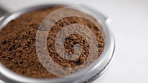 Closeup shot of ground coffee beans on a espresso portafilter