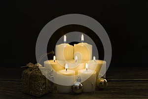 Closeup shot of a group of seven burning candles with black background