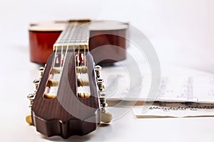 Closeup shot of guitar fingerboard and sheet with notes.