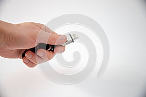 Closeup shot of a hand holding a USB stick isolated on a white background