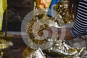 Closeup shot of a hand near a Buddha statue in Wat Yai Chaimongkol temple in Ayutthaya, Thailand