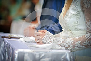 Closeup shot of hands of a bride. Bride's hand with engagement ring on and long lace sleeve