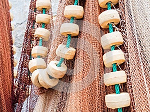 Closeup shot of hanging multicolored fishing nets and white beads on a green rope