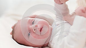 Closeup shot of happy smiling mother and adorable newborn baby boy lyin in crib against big window. Concept of family