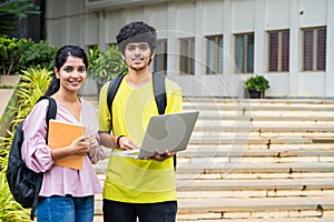 closeup shot of Happy smiling students with backpack holding laptop and smilling at camea at college campus - concept of