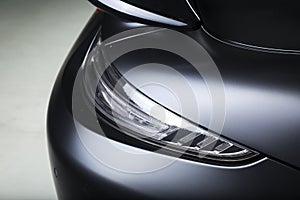 Closeup shot of the headlights of a modern black car