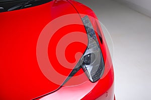 Closeup shot of the headlights of a modern red car