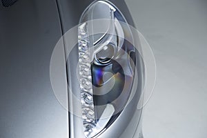 Closeup shot of the headlights of a modern silver car