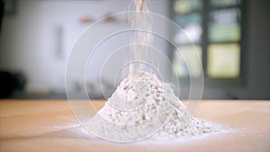 Closeup shot of a heap of wheat flour forming on a kitchen counter at home