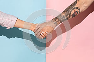 Closeup shot of human holding hands isolated on yellow studio background.