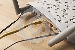 Closeup shot of an internet modem with a cable on a wooden surface