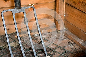 Closeup shot of an iron rake in the wooden hut