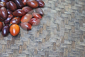 Closeup shot of jujubes bunch on a thatch table surface