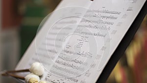 closeup shot of kettledrum musical instument, drum stick and sheet music