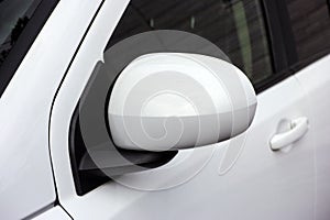 A closeup shot of the left car mirror of a white car