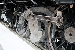 Closeup shot of locomotive gears and wheels on train tracks