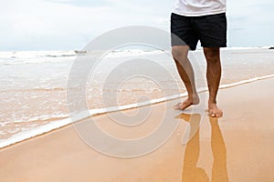 Closeup shot of male feet on smooth sand at the beach