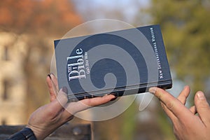 Closeup shot of a male and a female hand holding the Bible