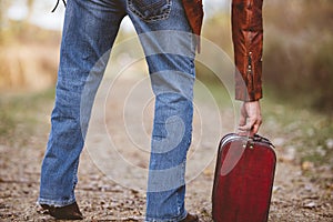 Closeup shot of a male grabbing his old suitcase - concept getting ready to travel