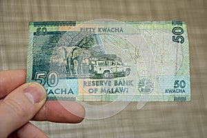 Closeup shot of a male hand holding Malawi 50 kwacha banknote