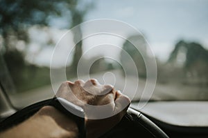 Closeup shot of a male hand on a steering wheel