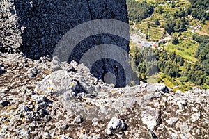 Closeup shot of male rock climbers on a mountain with a small village in the background