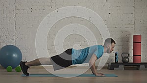 Closeup shot. Man fitness coach in sportswear doing classic push ups exercise for online class at the home studio. HDR