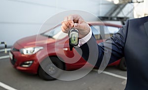 Closeup shot of man in suit showing car keys with remote control