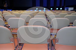 Closeup shot of many white chairs in rows in an event hall