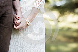 Closeup shot of a married couple holding hands with a blurred background