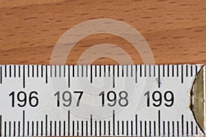 Closeup shot of measuring ruler with indicators in the form of centimetres on the wooden background