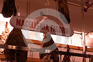 Closeup shot of a meat market named 'Macelleria Falorni" with meat hanging on the roof