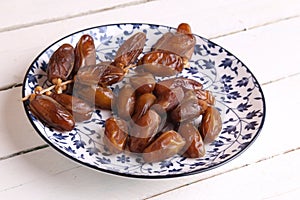 Closeup shot of medjool dates on in a decorative plate on a white table