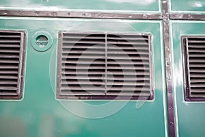 Closeup shot of metal ventilation grilles on green background