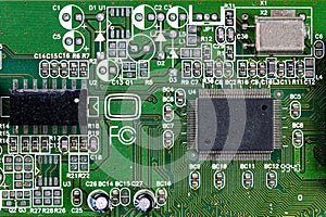 Closeup shot of microchip on green printed circuit board, computer motherboard with components