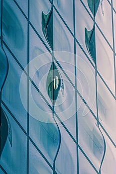 Closeup shot of a modern glass building with wavy blue window shapes