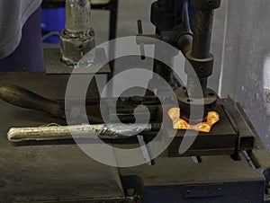 Closeup shot of molten glass in being pressed in a mold, making a glass candle holder