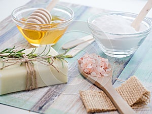 Closeup shot of natural skincare product ingredients: baking soda, honey, natural soap, and sea salt