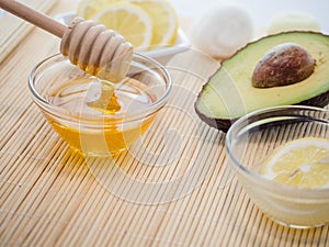 Closeup shot of natural skincare product ingredients: honey, lemon, and avocado