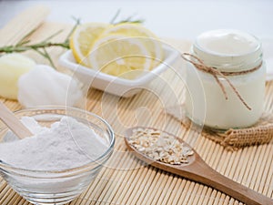 Closeup shot of natural skincare product ingredients: lemon, baking soda, yogurt, and oat flakes