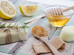 Closeup shot of natural skincare product ingredients: natural soap, lemon, honey, and brown sugar