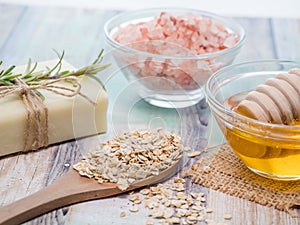 Closeup shot of natural skincare product ingredients: natural soap, oat flakes, honey, and sea salt