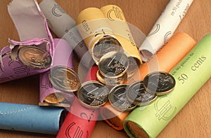 Closeup shot of newly opened packs of 1 and 2 euro coins placed on a wooden surface