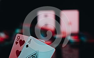 Closeup shot of a nine of hearts and an ace of spades on a poker table