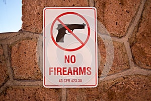 Closeup shot of a "No firearms" sign on the wall