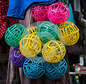 Closeup shot of numerous colorful hanging plastic balls under the light