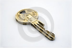 Closeup shot of an old gold key with german carvings on a white background