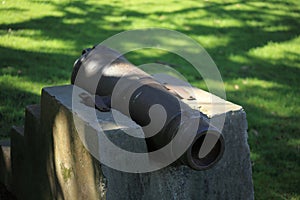 Closeup shot of an old iron cannon on a concrete pedestal in the park